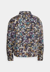 Chemise à manches longues avec fond sombre et motif floral dense en blanc, jaune, violet, orange et bleu sarcelle, vue de dos.