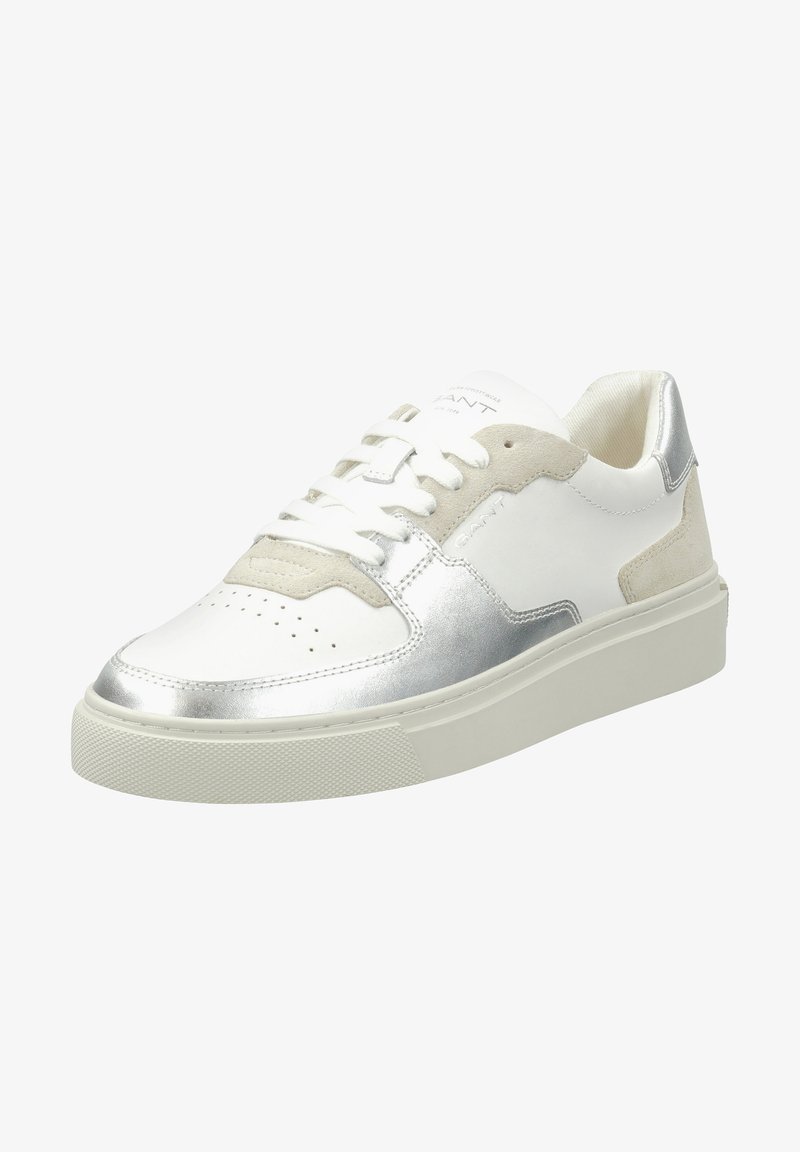 Weiße Sneaker mit silbernen Akzenten, Wildlederdetails, perforiertem Zehenbereich, runden Schnürsenkeln und einer strukturierten Gummisohle. Branding auf der Zunge sichtbar.