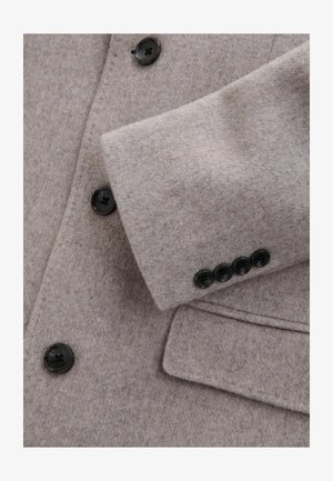 Hellgrauer Wollmantel mit Schößchenkragen, vier schwarzen Knöpfen an den Ärmeln und einer weichen, strukturierten Oberflächenausführung.