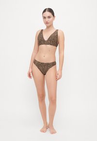 Ensemble de bikini comprenant un bralette à décolleté en V et un bas de bikini assorti dans un motif léopard brun et noir. Texture lisse, matériel minimal.