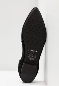 Semelle d'une chaussure noire à bout pointu avec une semelle rainurée, marque Pavement, taille 38, avec le texte « fabriqué à la main en Europe ».