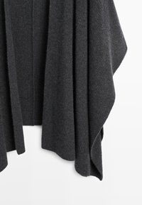 Tmavě šedá pletená vlněná tkanina s žebrovanými a texturovanými vzory, volně visící na bílém pozadí.