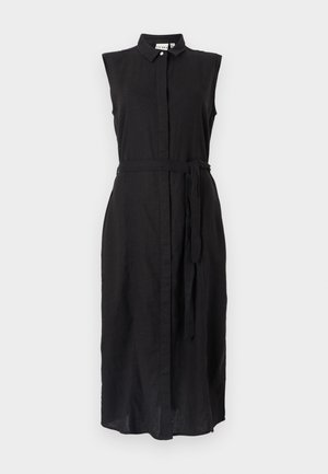 Juodas lininis sijonas su apykakle, be rankovių ir su juosmeniu surištas dirželiu. Yra priekiniai mygtukų užsegimai ir tiesus kirpimas.