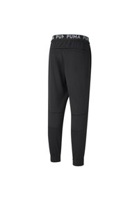 Schwarze Puma Jogginghose mit elastischem Bund, der das wiederholte Puma-Logo zeigt, und elastischen Bündchen an den Knöcheln, von hinten abgebildet.