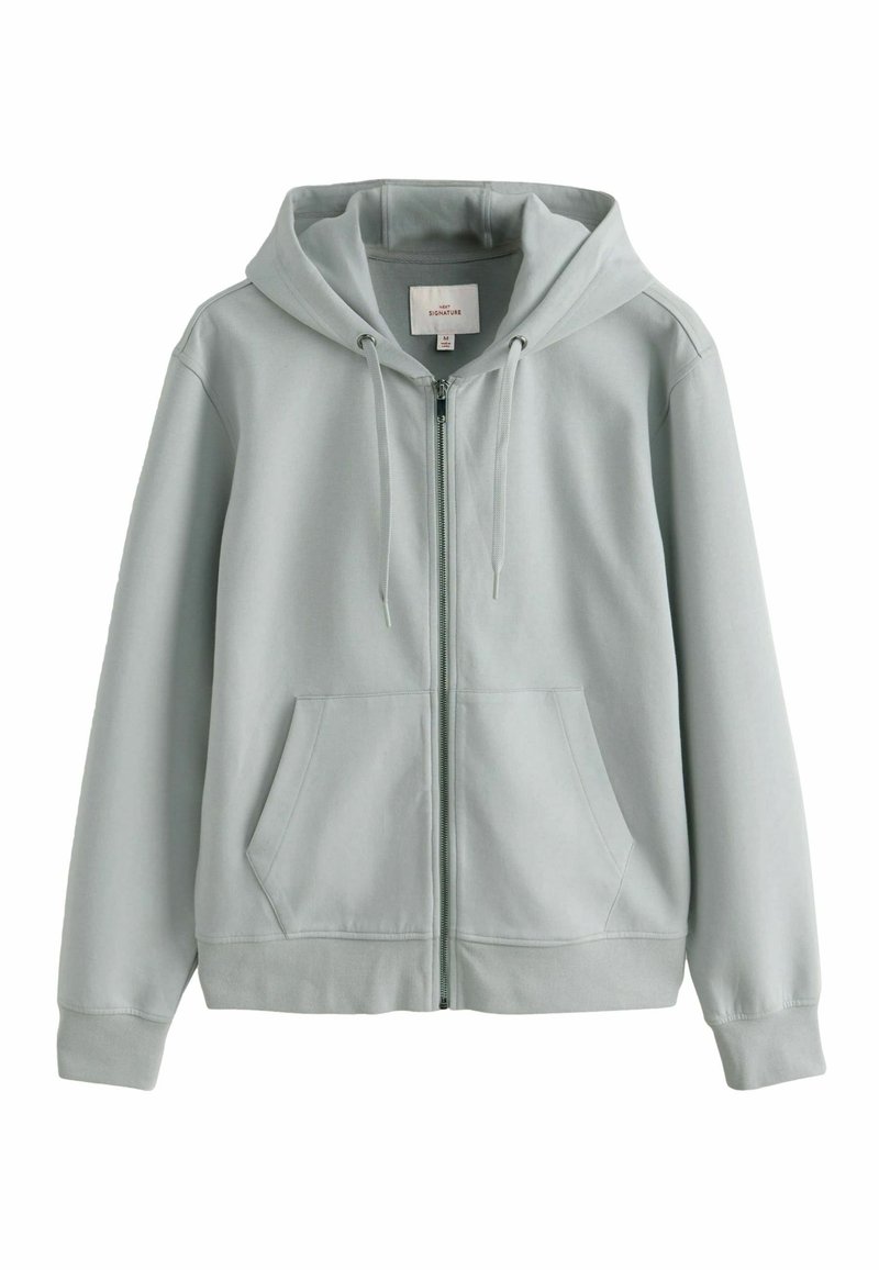 Hoodie gris clair en tissu doux, avec fermeture éclair, poches avant et capuche à cordon de serrage. Texture douce avec un tissu côtelé aux poignets.