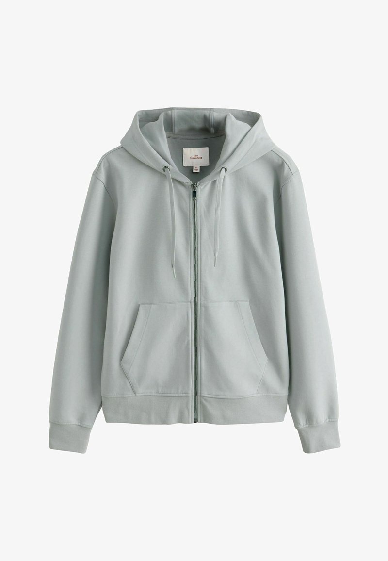 Hoodie gris clair en tissu doux, avec fermeture éclair, poches avant et capuche à cordon de serrage. Texture douce avec un tissu côtelé aux poignets.