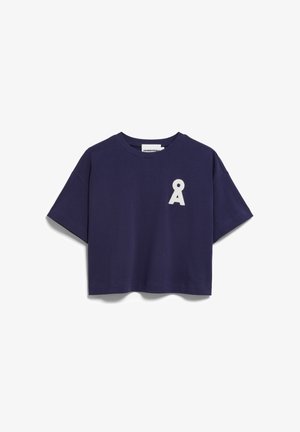 Marineblaues, kurz geschnittenes T-Shirt mit weiß besticktem schlüssellochförmigem Symbol auf der linken Brust.