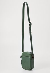 Borsa a tracolla verde in pelle con forma rettangolare, tracolla regolabile, chiusura con zip e tasca frontale. Caratterizzata da un design minimalista e un accento dorato.