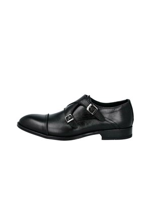 Zapato formal de cuero negro con hebillas de doble correa monk y un tacón bajo, mostrado de perfil sobre un fondo blanco.