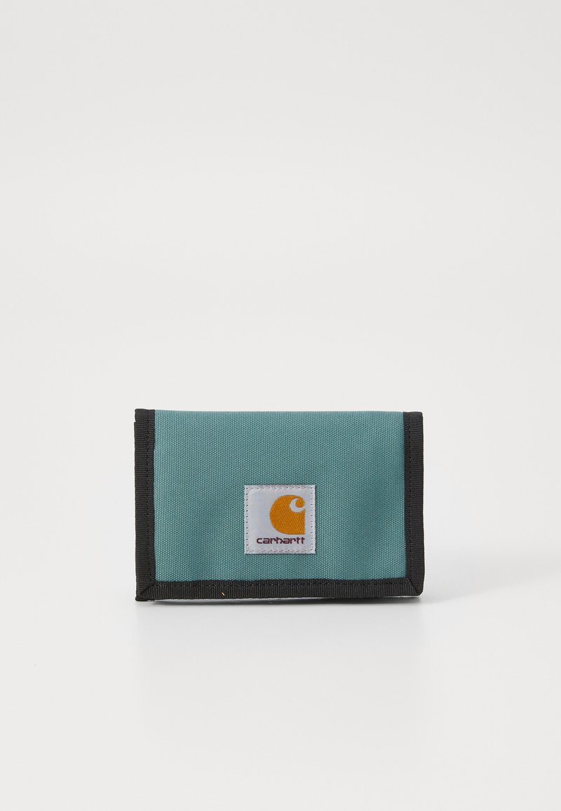 Portofel din țesătură teal cu margine neagră și un patch proeminent cu logo-ul portocaliu și alb Carhartt pe față. Formă compactă, rectangulară.