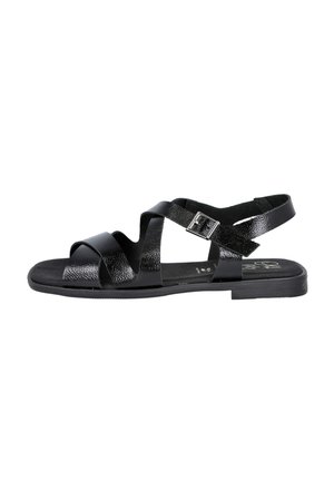 Sandalias negras con tiras entrelazadas de material texturizado, una correa trasera con un hebilla plateada y una suela plana.