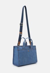 Sac à main rectangulaire en jean bleu avec des poignées courtes et une longue bandoulière réglable bleu foncé avec des accents marron.