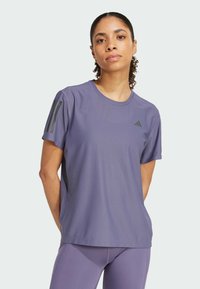 Lila Sport-T-Shirt aus atmungsaktivem Material mit Rundhalsausschnitt, kurzen Ärmeln und drei schwarzen Streifen auf der linken Schulter.