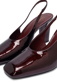 Bordeaux laksleren slingback hakken met een vierkante neus en een chunky hak. Glanzende afwerking met een uitsnede ontwerp aan de zijkanten.