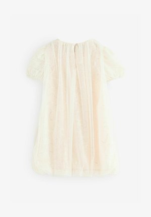 Pale cream dress with short puff sleeves, sheer overlay, and subtle glitter pattern. Fastens at the back with a small button.