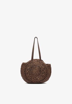 Sac cabas rond tissé marron avec longues anses en cuir et motif circulaire tressé complexe.