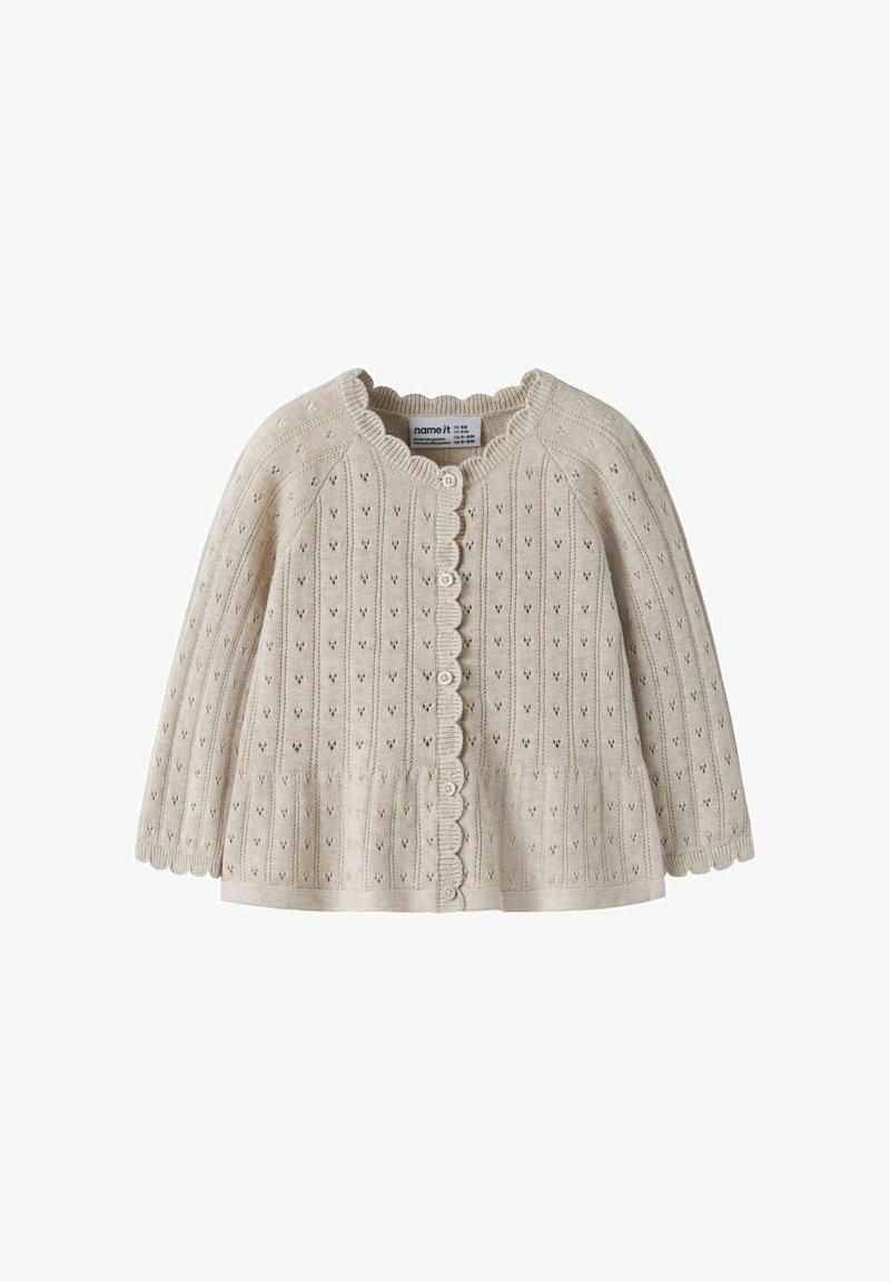 Cardigan bébé tricoté couleur crème avec manches longues, bords festonnés, petits boutons et délicat motif ajouré vertical.