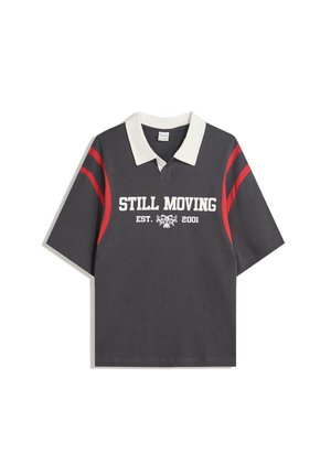 Gray short-sleeve polo shirt with a white collar, red stripes on sleeves, and front graphic text "STILL MOVING EST. 2001." Soft fabric texture.