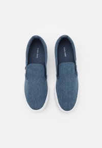 Blauwe denim instapschoenen met witte rubberen zolen. Heeft elastische zijpanelen en een logo op de binnenzool. Glad textuur met een eenvoudig ontwerp.