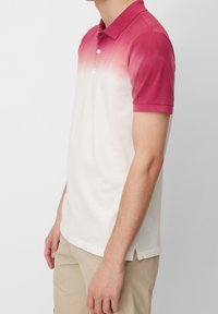Polo shirt avec un dégradé de rose à blanc, manches courtes, col, et une patte de boutonnage à deux boutons en tissu doux et texturé.