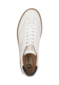 Sneaker in pelle bianca con punta rotonda, lacci piatti e suola in gomma marrone. Accentatura nera sul tallone. Logo visibile sulla soletta.