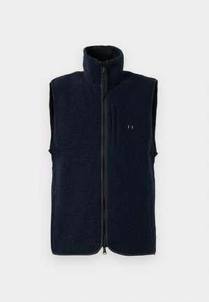 Navy fleece vest with high collar, full zipper closure, and front pocket. Textured surface and contrasting inner lining.