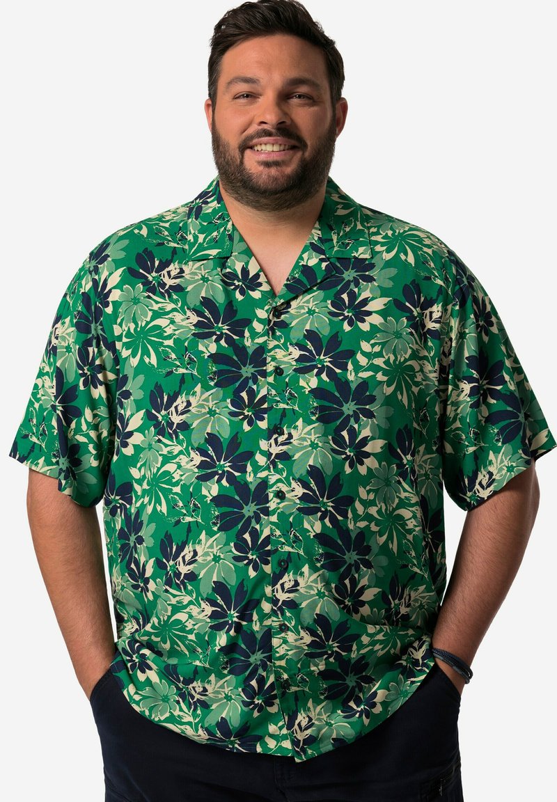 Camisa de manga corta, abotonada, en verde con patrones florales en azul oscuro y crema. Fabricada con un tejido ligero, cuenta con un cuello.