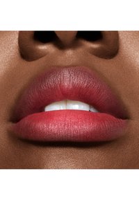 Gros plan sur des lèvres avec une finition mate en dégradé de nuances de rose profond, mettant en valeur une texture lisse et une forme définie sur une peau plus foncée.