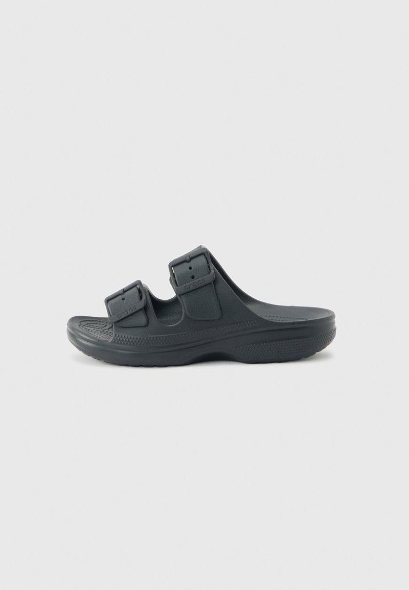 Sandale noire à enfiler avec deux brides à boucles réglables et semelle intérieure texturée, conçue pour un confort décontracté et un port facile.