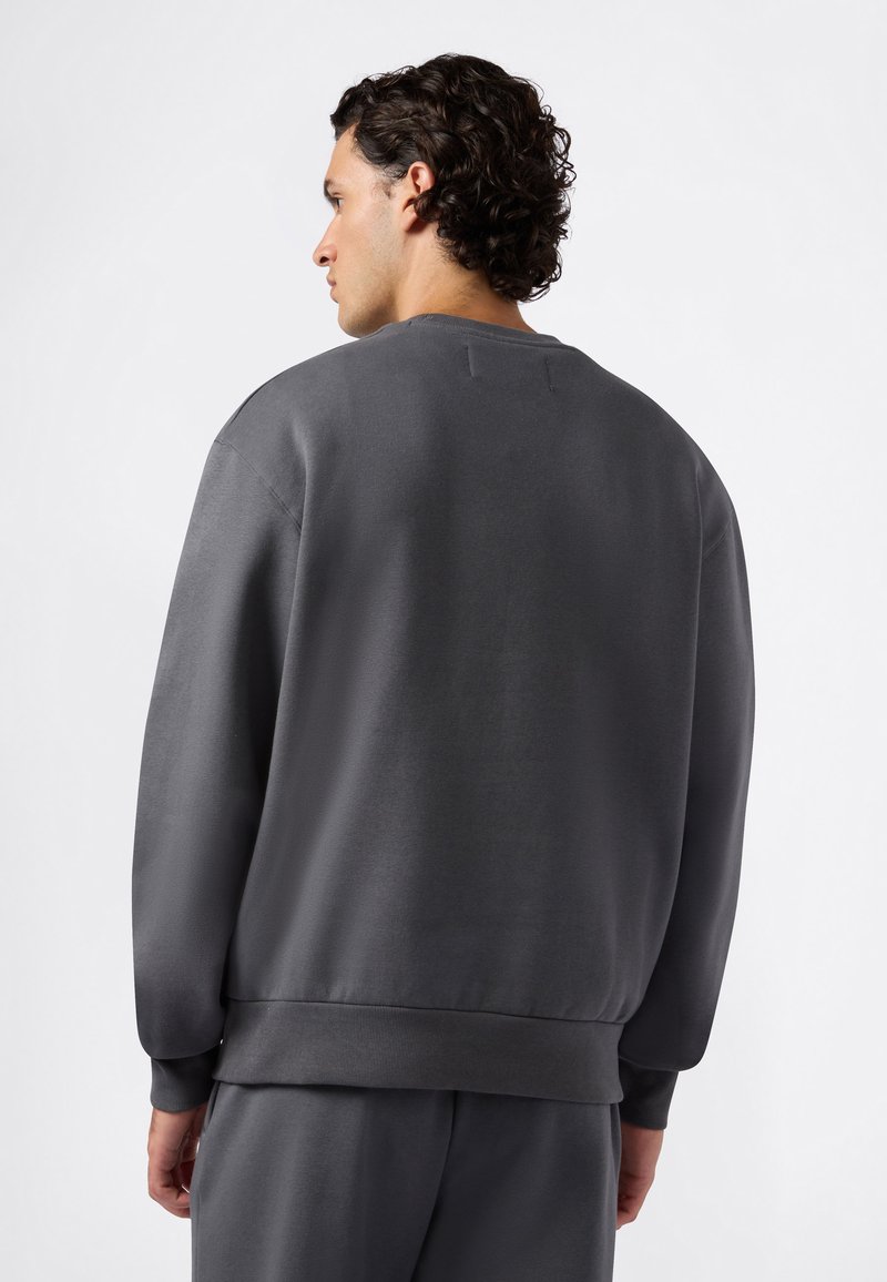 Grijze sweater met een ronde halslijn en geribbelde zoom. Gemaakt van een zacht materiaal, met een relaxte pasvorm en minimalistisch ontwerp.