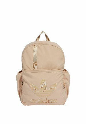 Mochila beige de Adidas con bolsillo frontal con cremallera, logotipo de camuflaje y detalle en la correa, además de bolsillos laterales para almacenamiento adicional.
