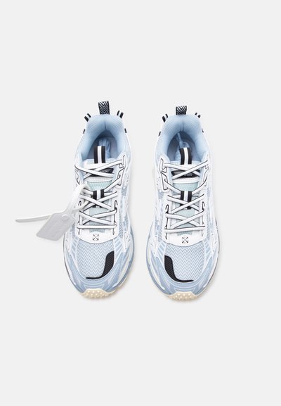 Ζευγάρι αθλητικών παπουτσιών σε ανοιχτό μπλε και λευκό χρώμα, με ύφασμα διχτυού, μαύρες λεπτομέρειες και καρτελάκι προσαρτημένο στο αριστερό παπούτσι, από άνω οπτική γωνία.
