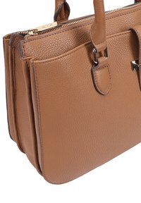 Bruine leren handtas met een gestructureerde oppervlakte, dubbele handvatten, ritsluiting en een buitenzak met zilveren hardware accenten.