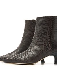 Brown faux snake skin ankle boots with pointed toes and a low block heel. Features a textured pattern and a sleek design.