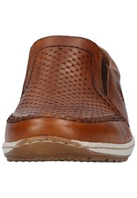 Brauner Leder Slipper mit perforiertem Design, runder Zehenform, kontrastierender weißer Sohle und sichtbaren Nahtdetails entlang des Rands.