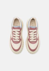 Zapatillas con un diseño bicolor que presentan una parte superior de cuero rosa claro, una puntera crema y acentos en azul claro. Cordinas gruesas blancas y suela.