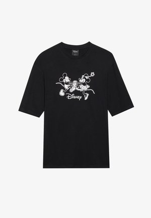 Fekete, rövidujjú póló, amelyen Mickey és Minnie Mouse kéz a kézben állnak, fehér grafikával, a minta alatt pedig a "Disney" felirat található.