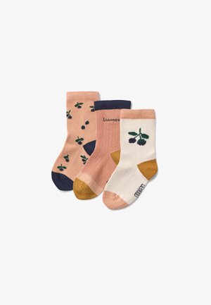 Set of three socks in different colors: peach with green leaf pattern, solid light peach, and white with green leaves and mustard accent.