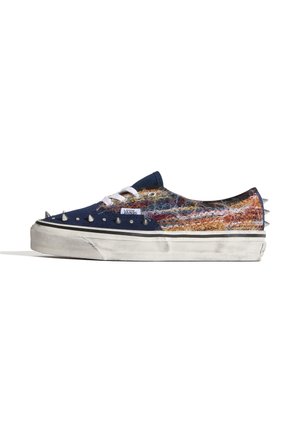 Sneaker Vans low-top con parte anteriore blu navy, tessuto peloso multicolore, lacci bianchi, suola bianca e punte argento sulla punta, lati e tallone.