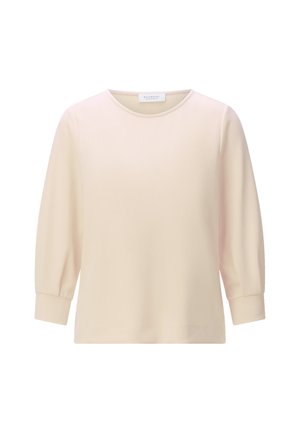 Cremefarbene Langarmbluse mit rundem Ausschnitt und leicht gepufften Ärmeln, die in breiten Manschetten enden.