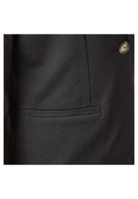 Blazer noir avec un revers en point, deux boutons et une poche latérale. Le tissu a une texture lisse avec un léger éclat.