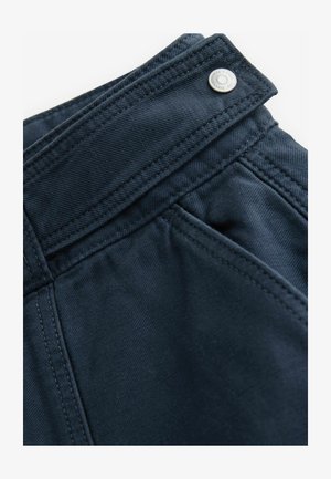 Pantaloni negri închis, dintr-un material neted, cu buzunare diagonale și un detaliu din metal pe talie. Cusăturile sunt îngrijite și vizibile.