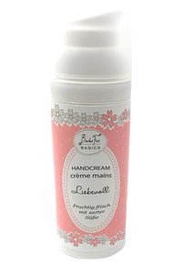 Rosa Handcreme-Tube mit einem weißen Deckel, verziert mit floralem Muster und Punkten. Aufkleber enthalten "HANDCREME" und Duftbeschreibung.