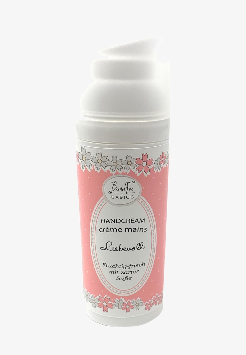 Rosa Handcreme-Tube mit einem weißen Deckel, verziert mit floralem Muster und Punkten. Aufkleber enthalten "HANDCREME" und Duftbeschreibung.