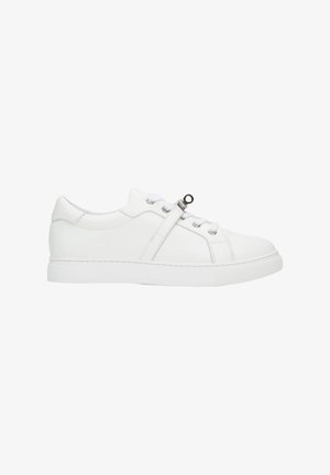 White leather sneaker with a rounded toe, flat rubber sole, and metal eyelets. Features a diagonal strap across the upper.