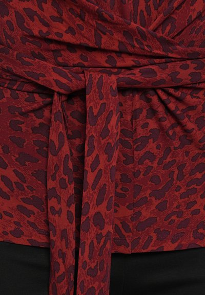 Rode top met een luipaardprint in variërende tinten bordeauxrood. Heeft een gestrikte riem in de taille en een gestructureerde stof.