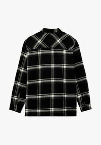 Czarna i biała flanelowa koszula w kratę, z długimi rękawami, kołnierzykiem i mankietami na guziki. Posiada karczek z tyłu oraz gładką, miękką fakturę.