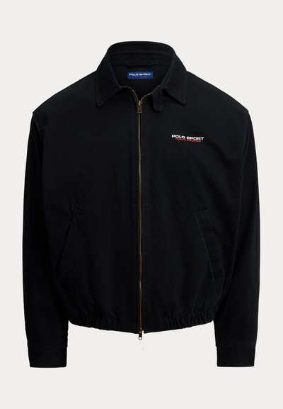 Sort lynlåstrøjejakke lavet af letvægtsstof; har krave, elastisk kant, sidelommer og rød og hvid "Polo Sport" logo detalje.