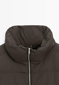 Ciemnobrązowa kurtka puchowa z wysokim kołnierzem, zapinana na zamek błyskawiczny na całej długości, o gładkiej, lekko błyszczącej fakturze.