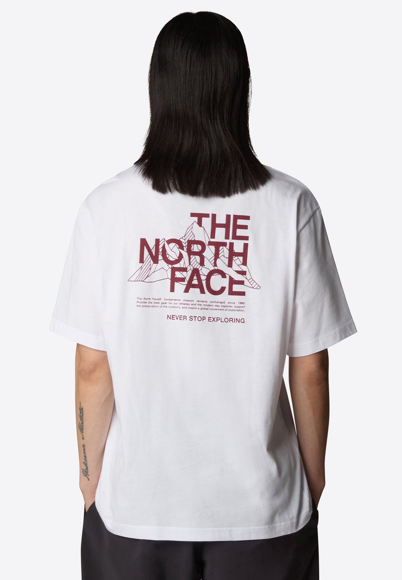 Camiseta de algodón blanca con un gráfico rojo en la parte posterior que presenta el texto "THE NORTH FACE" y un diseño de montaña, de mangas cortas y ajuste relajado.